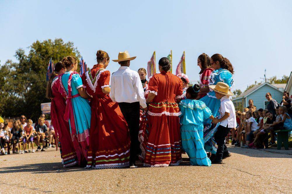 Dance troupe members holding hands in a circle