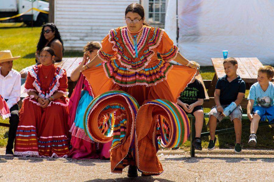 A dancer twirling in a bright orange dress