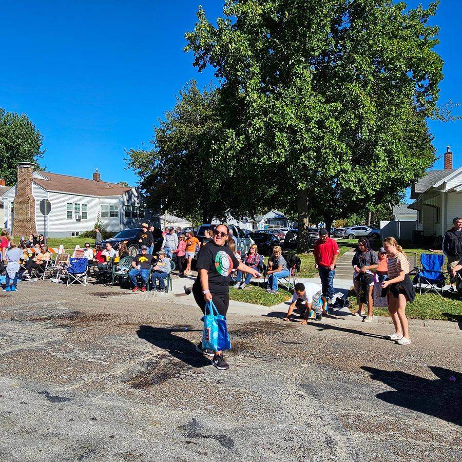 A parade participant tossing candy to the crowd