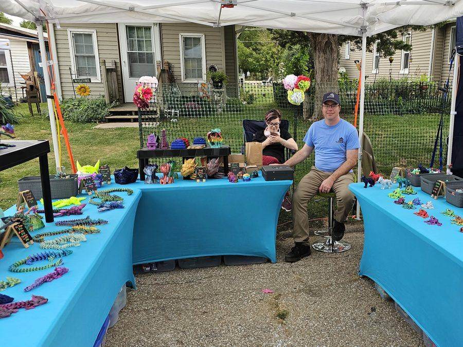 A vendor booth selling 3D-printed dragons and fantasy figures