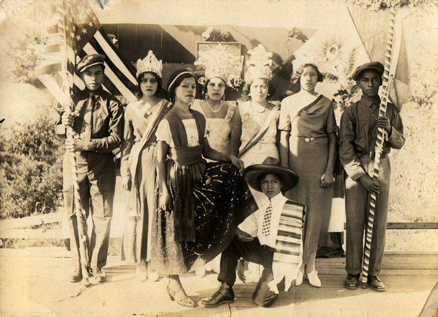 Archival black-and-white photo of Fiesta court members holding flags